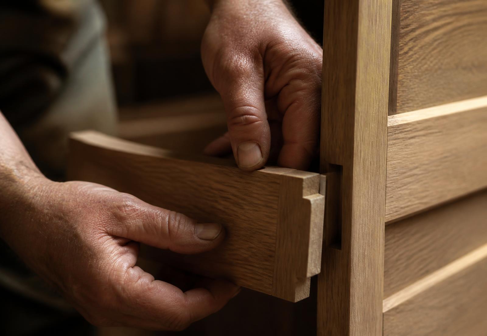 Carpenter fitting custom oak millwork joinery on a Right Choice Restoration project
